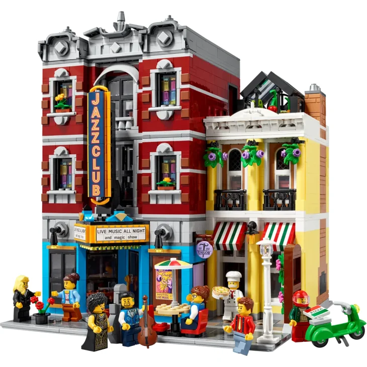 Gesamtansicht des LEGO Jazz Club Sets mit rotem Backsteingebäude, blauem Schild, gelbem Restaurant, Figuren und grünem Roller