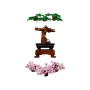 LEGO Bonsai mit grünem Laub, gebogenem braunem Stamm in schwarzem Topf auf Holzsockel und separatem rosa Kirschblütenzweig