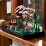 LEGO-Zen-Garten mit japanischem Pavillon, rosa Kirschblütenbaum, roter Brücke, grünen Pflanzen auf schwarzer Basis LEGO-Zen-Garten mit japanischem Pavillon, rosa Kirschblütenbaum, roter Brücke, grünen Pflanzen auf schwarzer Basis
