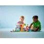 Zwei Kinder spielen mit LEGO Jahrmarkt-Set: buntes Karussell, rot-weiß gestreifter Leuchtturm und DUPLO-Figuren