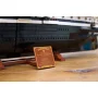 LEGO Endurance-Schiff mit schwarzem Rumpf und weißen Details, präsentiert mit goldener Infotafel auf Holzsockel