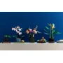 Rosa-weiße LEGO-Orchidee in grau gestreiftem Topf auf weißem Regal neben anderen botanischen Pflanzen Rosa-weiße LEGO-Orchidee in grau gestreiftem Topf auf weißem Regal neben anderen botanischen Pflanzen