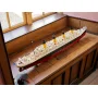Zusammengebautes LEGO Titanic-Modell auf Holzmöbel, zeigt roten Rumpf, weißes Deck und 4 gelbe Schornsteine mit Details