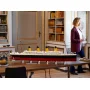 LEGO Titanic-Modell auf Holztisch präsentiert, zeigt schwarzen Rumpf, gelbe Schornsteine und weiße Oberdeckdetails in elegantem Raum