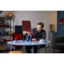 Mann sitzt an rundem Tisch und betrachtet die rot-blaue LEGO Optimus Prime Figur in modernem Wohnzimmer
