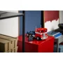LEGO Optimus Prime als rot-blauer Lastwagen auf einem roten Würfel in moderner Umgebung mit Regalen