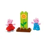 Peppa Pig im roten Kleid und George im blauen Overall neben großer LEGO-Sonnenblume auf brauner Basis
