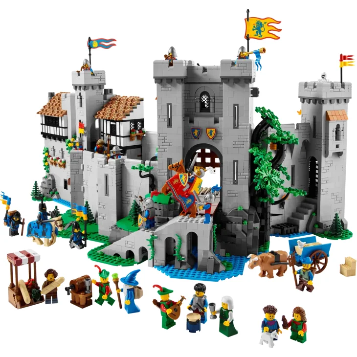 Vue d'ensemble du château LEGO avec tours grises, pont-levis, dragon vert, chevaliers et accessoires médiévaux disposés autour