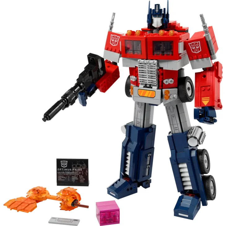 Robot Optimus Prime LEGO en configuration robot, rouge, bleu et gris, tenant un canon, avec accessoires et plaque descriptive