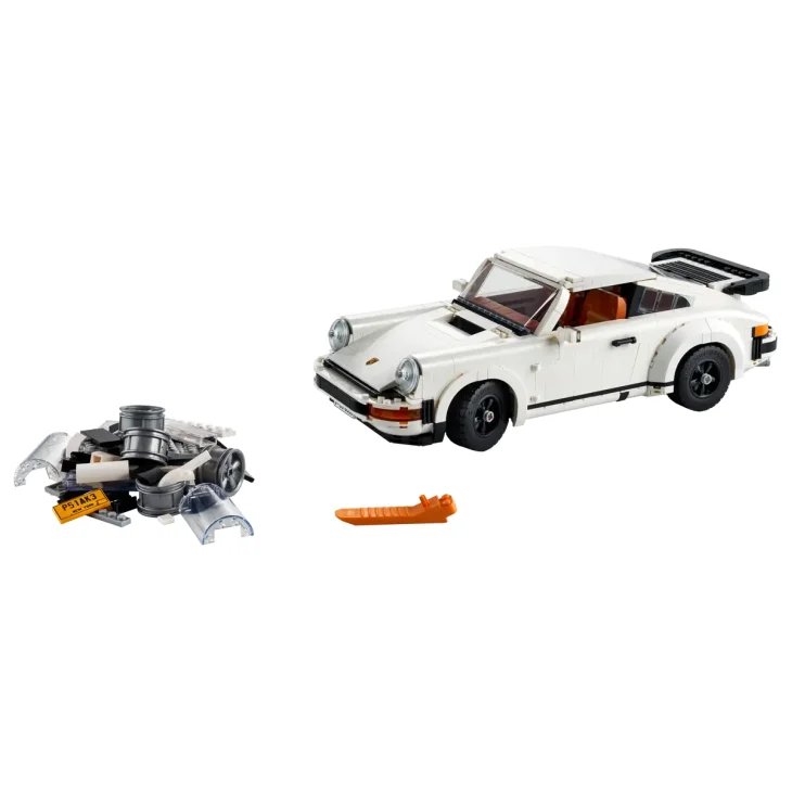 Porsche 911 LEGO blanche avec aileron noir, moteur détaillé et petit outil orange sur fond blanc