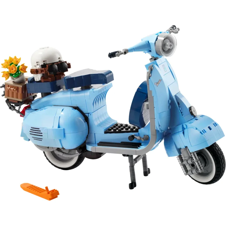 Scooter Vespa LEGO bleu clair avec panier de fleurs, béquille déployée et accessoires orange au sol