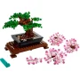 Bonsaï LEGO avec feuillage vert sur socle brun, accompagné de branches roses détachées et d'un outil de démontage turquoise Bonsaï LEGO avec feuillage vert sur socle brun, accompagné de branches roses détachées et d'un outil de démontage turquoise