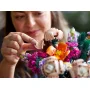 Vue rapprochée d'une femme assemblant délicatement une fleur LEGO rose du bouquet coloré avec ses doigts Vue rapprochée d'une femme assemblant délicatement une fleur LEGO rose du bouquet coloré avec ses doigts