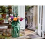 Bouquet de fleurs LEGO colorées dans un vase vert transparent posé sur une table, avec jardin en arrière-plan Bouquet de fleurs LEGO colorées dans un vase vert transparent posé sur une table, avec jardin en arrière-plan