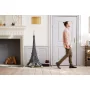 Set LEGO tour Eiffel assemblée en noir dans un salon moderne avec cheminée, homme marchant en arrière-plan Set LEGO tour Eiffel assemblée en noir dans un salon moderne avec cheminée, homme marchant en arrière-plan