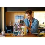Homme construisant le set LEGO Le club de jazz avec bâtiment modulaire coloré et figurines sur une table Homme construisant le set LEGO Le club de jazz avec bâtiment modulaire coloré et figurines sur une table