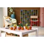 Collection de neuf plantes miniatures LEGO dans des pots en terre cuite disposées sur une table blanche moderne