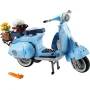 Scooter Vespa LEGO bleu clair avec panier de fleurs, béquille déployée et accessoires orange au sol
