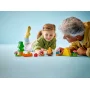 A little girl and her grandfather playing together with LEGO camping set featuring yellow tent, pine tree, orange canoe and figures