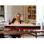 Woman building the LEGO Titanic model on a table, ship with 4 yellow funnels and black hull visible Woman building the LEGO Titanic model on a table, ship with 4 yellow funnels and black hull visible