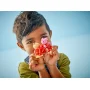 Child holding LEGO Peppa Pig and Suzy Sheep figures wearing pink and red party dresses Child holding LEGO Peppa Pig and Suzy Sheep figures wearing pink and red party dresses