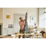 Man proudly holding the completed LEGO Eiffel Tower model in a modern living room with wooden table