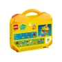 Yellow LEGO carrying case with handle, displaying colorful builds on packaging: houses, cars and minifigures Yellow LEGO carrying case with handle, displaying colorful builds on packaging: houses, cars and minifigures