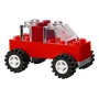 Red LEGO vehicle with four large black wheels, transparent windshield and colorful bricks stacked in the back Red LEGO vehicle with four large black wheels, transparent windshield and colorful bricks stacked in the back