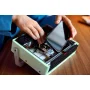 Hand placing smartphone into opened LEGO retro radio, revealing detailed interior with mechanisms and components Hand placing smartphone into opened LEGO retro radio, revealing detailed interior with mechanisms and components