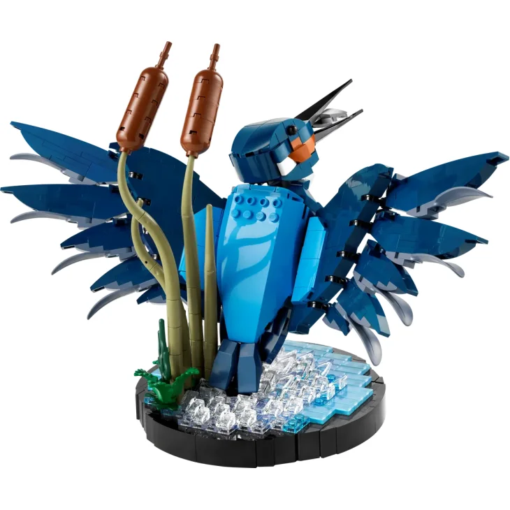 Martín pescador LEGO azul con alas extendidas posado en base circular con juncos y efecto de agua cristalina