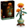 Crisantemo LEGO con flores naranjas en jarrón verde sobre soporte marrón, junto a su caja de embalaje