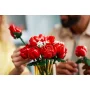 Ramo de rosas rojas LEGO en jarrón dorado con paniculata blanca, sostenido por manos