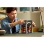 Un constructor ajusta el Book Nook LEGO del Balrog con llamas naranjas iluminadas y Gandalf en el puente