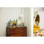 Vista general del set LEGO Rivendel expuesto sobre cómoda de madera en salón moderno con mujer al fondo
