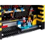 Primer plano de la máquina arcade LEGO PAC-MAN con pantalla de juego, palancas azules, minifigura jugador y mecanismo interno