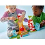 Dos niños juegan con el set LEGO feria: carrusel colorido, castillo hinchable rojo y blanco, caseta de juegos azul