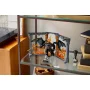 Set LEGO Balrog con ali spiegate e frusta infuocata, esposto su scaffale in vetro tra libri Set LEGO Balrog con ali spiegate e frusta infuocata, esposto su scaffale in vetro tra libri