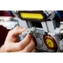Primo piano di mani che assemblano un pezzo LEGO dettagliato della navicella, con elementi grigi e gialli del Firespray sullo sfondo