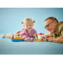 Una bambina e suo nonno che giocano insieme con il set LEGO di Peppa Pig, con una barca colorata e un faro Una bambina e suo nonno che giocano insieme con il set LEGO di Peppa Pig, con una barca colorata e un faro
