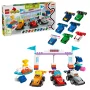Scatola LEGO DUPLO ed elementi sparsi: auto F1 colorate, piloti, podio con bandiere e trofeo dorato Scatola LEGO DUPLO ed elementi sparsi: auto F1 colorate, piloti, podio con bandiere e trofeo dorato