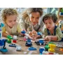 Tre bambini che giocano insieme con auto da corsa LEGO blu e verdi su un tappeto, supervisionati da un adulto Tre bambini che giocano insieme con auto da corsa LEGO blu e verdi su un tappeto, supervisionati da un adulto
