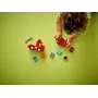 Bambino che gioca con camion dei pompieri LEGO rosso e vari mattoncini colorati su sfondo verde