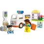 Witte LEGO-ambulance met blauwe zwaailichten, chauffeur in geel uniform met brancard, zittend kind, stoplicht en kleurrijke gebouwen