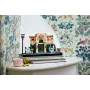 LEGO Frans café in beige en groen met terras, straatlantaarn en poppetjes, op boeken in bloemig interieur