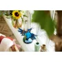 LEGO-ijsvogel met blauwe en oranje veren op een standaard, geplaatst op een vensterbank naast bloemen