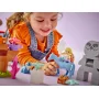 Kind speelt met LEGO-set: Elsa-figuur op blauwe slee getrokken door Bruni de salamander, met boselementen eromheen