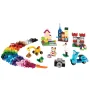 Regenboog van kleurrijke LEGO-stenen met bouwwerken: huis, kasteel, voertuigen, camera en poppetjes op witte achtergrond